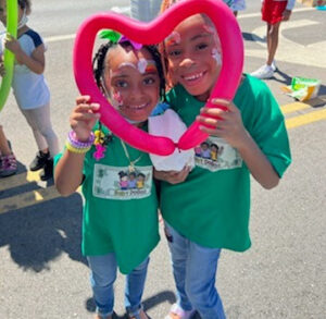 Two kids holding a heart shaped balloon